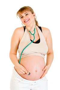 快乐怀孕的女人在她的肚子上持有 stethascope