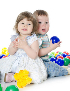 小小的女孩和男孩扮演孤立的多色彩的球