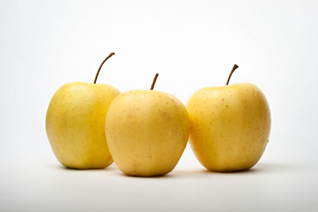个苹果三个黄色的有机苹果三个黄色斑点苹果生长在树枝上, 近距离水果