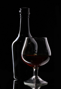 白兰地和黑色背景上的瓶玻璃