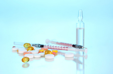 胰岛素注射器与医疗安瓿和在蓝色背景上片
