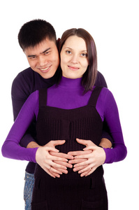 在对年轻快乐怀孕夫妇爱工作室在黑色背景上的特写