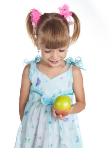 漂亮的女孩穿上蓝裙子与她手里的苹果