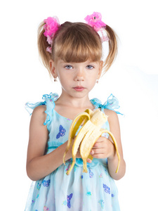 有在她手中的香蕉穿上蓝裙子的漂亮女孩