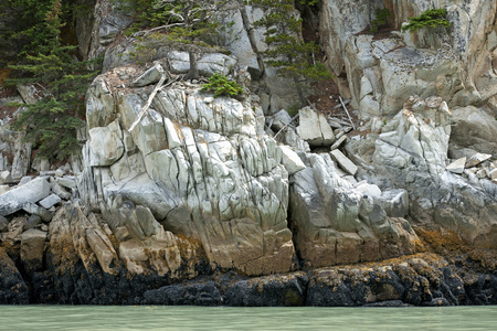 岩石在美丽的颜色,在水边创建石头墙照片