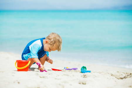 男孩热带海滩上玩沙滩玩具