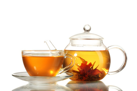异国情调绿茶与鲜花在玻璃茶壶和杯子上白色隔离