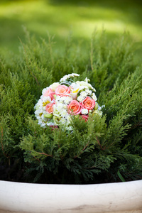 在绿色的草丛中的粉色和白色婚礼花束