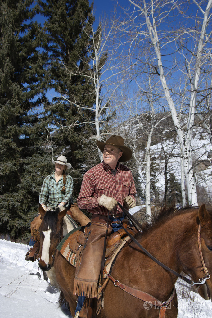 男人和女人骑着马在雪中