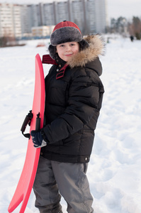 一个男孩与雪橇的肖像