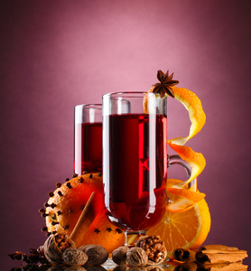 芬芳的美酒在眼镜 香料和紫色背景上的橙色