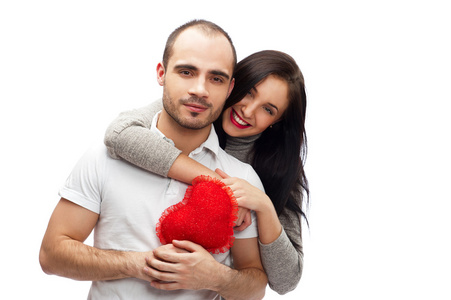 快乐的年轻成人夫妻用拥抱着笑着，在白色背景上的红色心