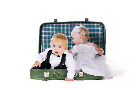 男孩和一个女孩坐在一个手提箱，去旅行