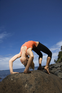 做瑜伽在海岸上的女人