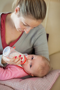 母亲用奶瓶喂养婴儿女孩
