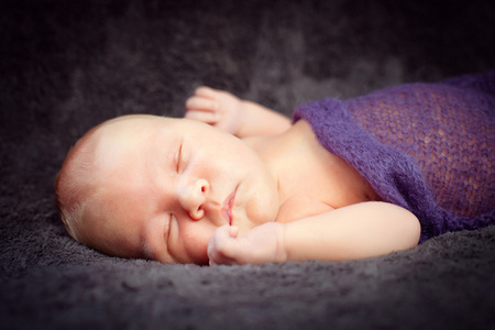 和平地睡在软毯下的初生男婴图片