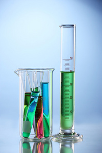 实验室玻璃器皿与颜色液体和蓝色背景的思考