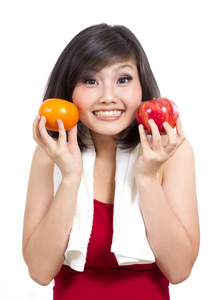 年轻漂亮的姑娘展示橙和苹果