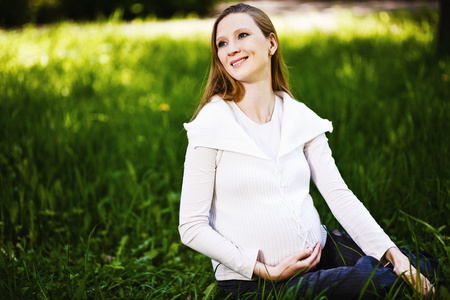 怀孕的女人放松在公园