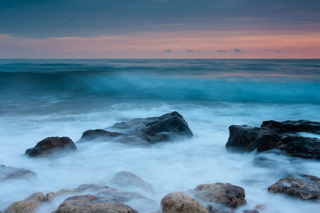 美丽的岩石海海滩日落时