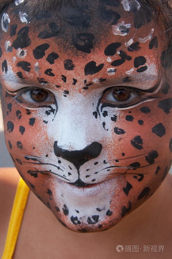 可爱的女孩孩子脸与彩绘的豹颜色掩码