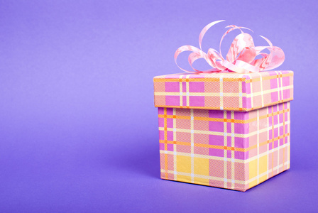 蓝色背景上的粉红丝带单黄色礼品盒