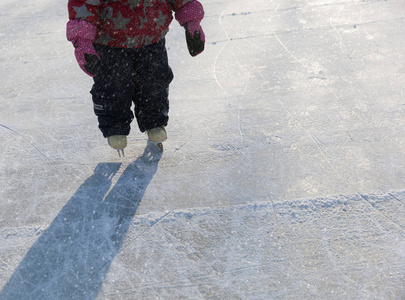 学习在冬天在冰上滑冰的孩子脚
