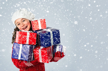 快乐的小女孩，与雪背景上的圣诞礼物