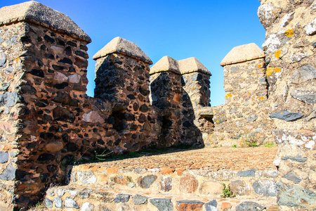在西班牙安达鲁西亚的Huelva，一个名为CumbresMayores的村庄，在晴朗和阳光明媚的秋日，城堡墙上有堡垒和加固塔