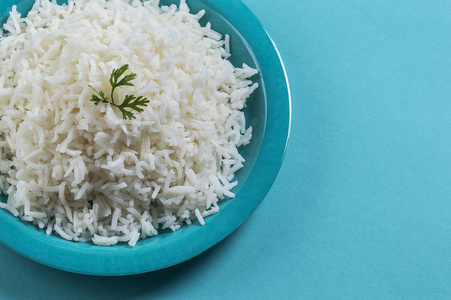 米饭纯白色印度香米与香菜在蓝色背景上的蓝色板