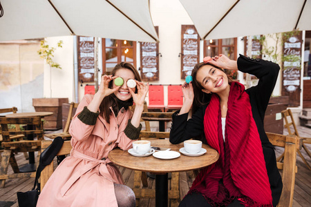 两个有趣的女人喝咖啡与杏仁和开心