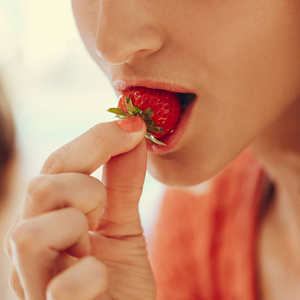 年轻女子吃草莓