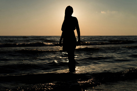 在日落沙滩上的剪影女人