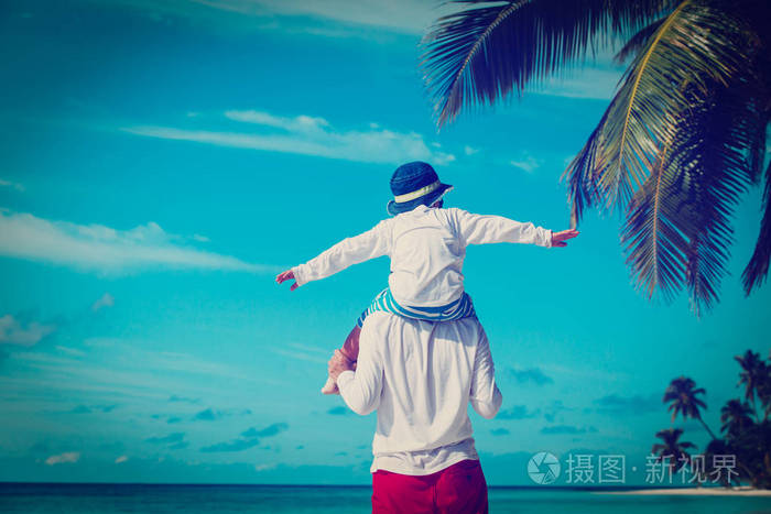 快乐的父亲和儿子在肩膀上玩着天空