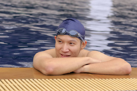 亚洲帅哥在游泳池戴游泳帽和护目镜