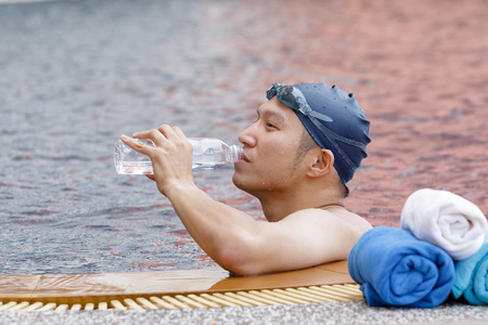 后池亚洲游泳运动员正在喝水,池里游泳后照片