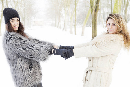 母女俩手牵着手在雪中
