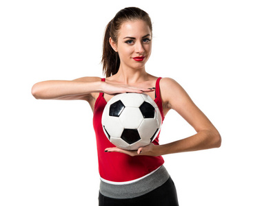 漂亮的运动位妇女抱着一个足球
