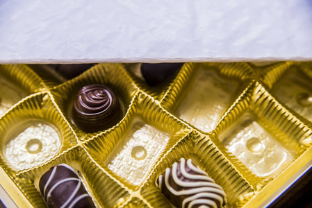 从上面看一盒巧克力部分空。盒子的巧克力松露，特写，从丰富多彩的巧克力，巧克力礼物选择