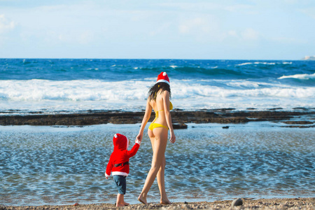 圣诞老人男孩和女人在海滩