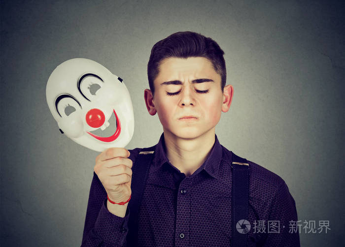 伤心的男人脱下快乐的小丑面具人格分裂