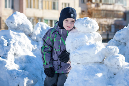 搞笑小孩子男孩穿着五颜六色的服装,在降雪期间在户外玩.