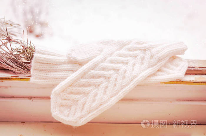 冬天的场面与白色针织的羊毛温暖的手套