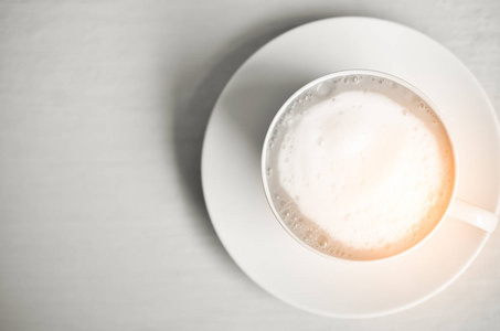 早上在白色的木桌上的白色杯复制空间的顶视图热奶茶