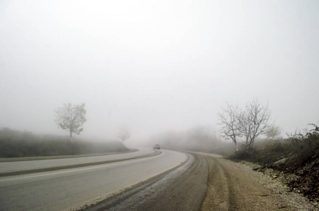 的黑暗树木或在冬天的时候，阿塞拜疆smailli山道路上雾之间有雾沥青道路景观