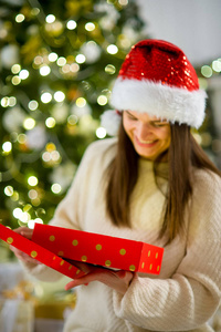 漂亮的女孩与圣诞礼物打开一个盒子，黑发女人