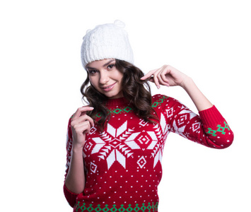 微笑很的年轻女性，穿着五颜六色织件毛衣与圣诞节装饰品和帽子。白色背景上的孤立。冬天的衣服