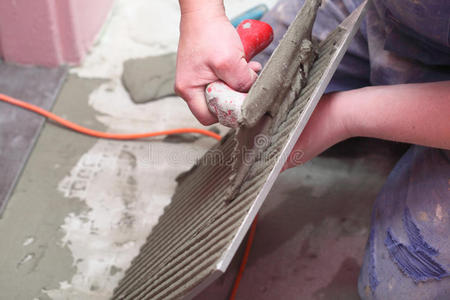 建筑工人正在家里贴瓷砖地板胶照片