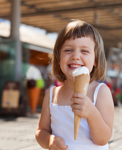 在街上吃冰淇淋的女孩