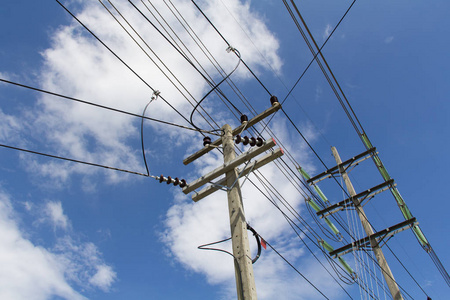 电线杆连接到蓝天背景上的高压电线上.照片